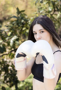 Brunette woman with boxing gloves protecting herself