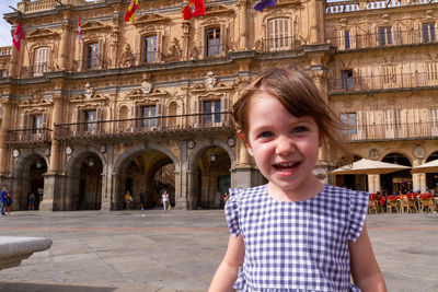 Portrait of smiling girl against building