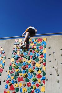 Low angle view of person against blue sky