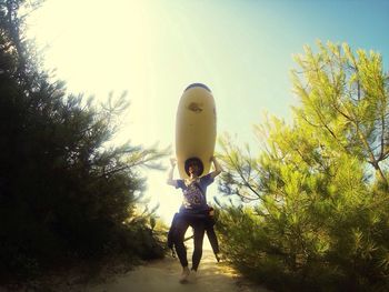 Full length of woman standing on tree trunk