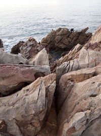 Rock formation on sea shore against sky