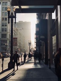 People walking on street amidst buildings in city