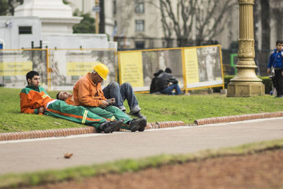 People sitting on road against buildings