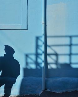 Rear view of silhouette man standing by railing