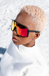 A young african american woman wearing sunglasses having fun in the snow on a winter day