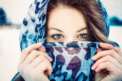 Close-up portrait of smiling young woman in snow