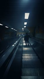 Rear view of man walking on railroad station platform