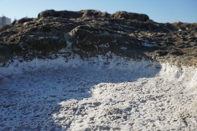 Close-up of rocks in sea against sky