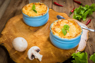 Pots with mushroom julienne on a wooden board.