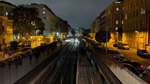 High angle view of illuminated street amidst buildings at night