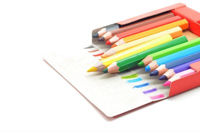 High angle view of colored pencils on white background