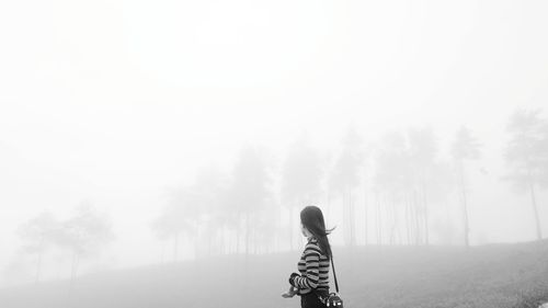 Rear view of woman standing on road