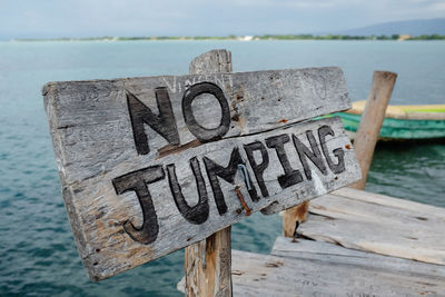 Wooden no jumping sign on wooden boardwalk