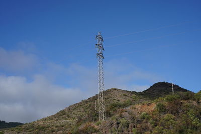 Low angle view of electricity pylon against sky