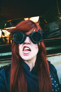 Woman showing tongue wearing sunglasses
