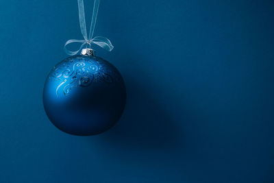 Close-up of christmas decoration hanging against blue background