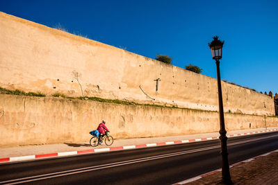 Man on road against blue sky