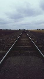 Railroad track against cloudy sky