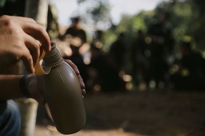 Cropped hands holding bottle