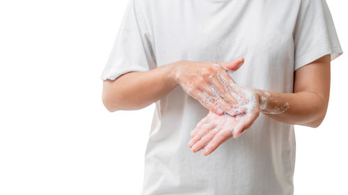 Midsection of man with arms raised against white background