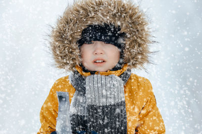 Adorable little boy outdoors on a beautiful winter snowy day