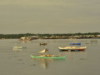 Boats moored in sea against sky