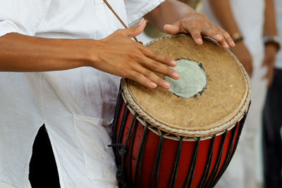 Midsection of man playing drum