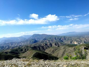 Scenic view of mountains against blue sky