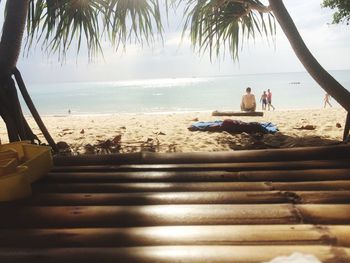 Rear view of people relaxing on beach