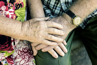 Midsection of couple holding hands