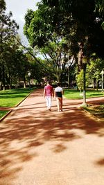 Rear view of woman walking on footpath