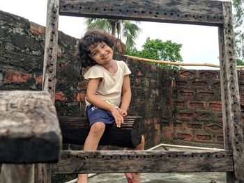 Portrait of smiling little girl sitting outdoors