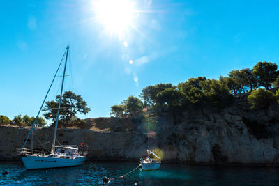 Boats sailing in river against sky