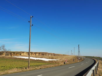 Country road against clear blue sky