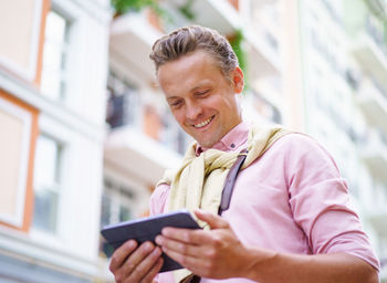 Young man using mobile phone in city