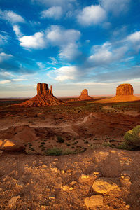 Rock formations on landscape against cloudy sky