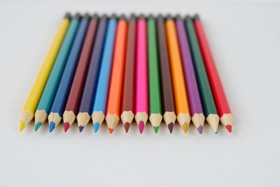 High angle view of colored pencils against white background