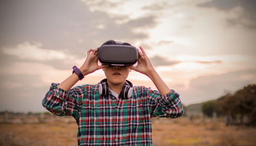 Man in tartan shirt wearing virtual reality headset reality in beautiful sky nature and technology 