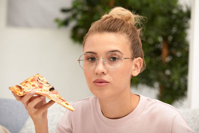 Portrait of young woman holding food