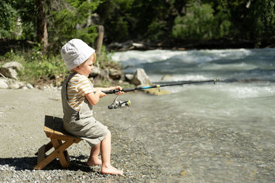 Cute boy fishing in river