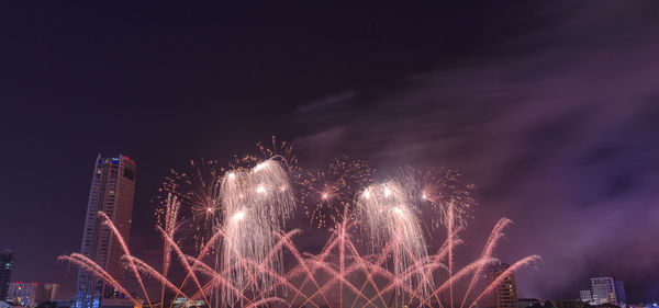 Low angle view of firework display at night