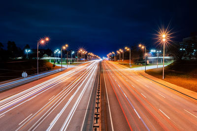 Bright lights from cars and street lamps on the highway at night