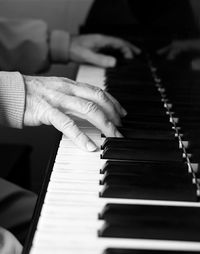 Cropped image of person playing piano