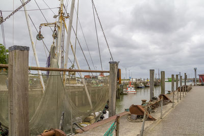 Sailboats moored at harbor against sky