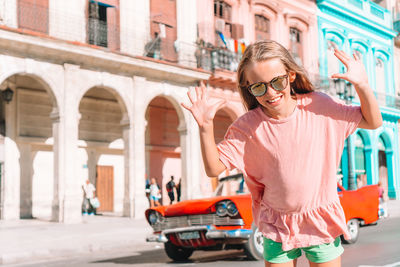 Portrait of girl wearing sunglasses on street in city