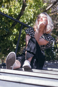 Full length of woman sitting outdoors