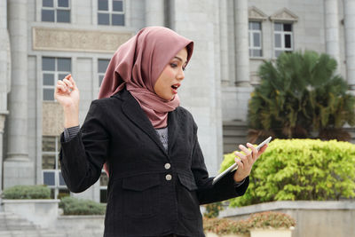 Full length of young woman standing outdoors