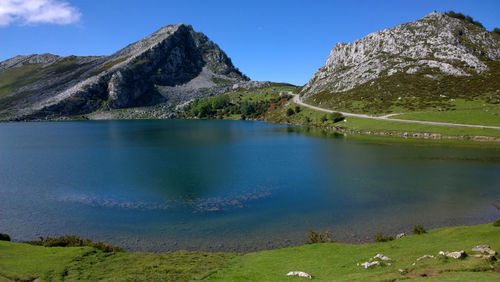 Scenic view of lake and mountains against blue sky