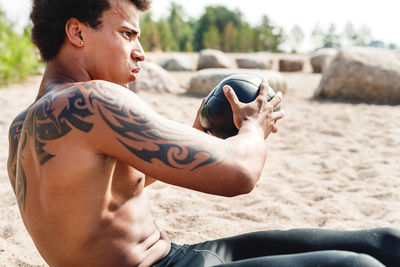 Side view of young man looking at beach