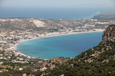 High angle view of city by sea against sky